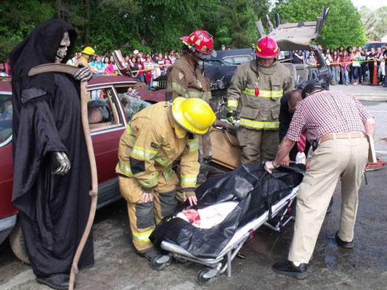 Death looks on as a teen is placed in a body bag