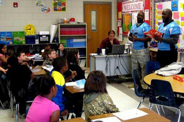 Members of the Hinesville Huerricanes reading a story to Mr. Drew Toneys class.