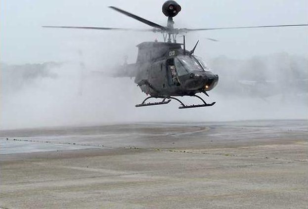 a Kiowa emerges from water cannon spray as part of final flight ceremony