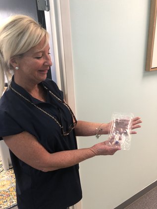 Sheila Bonner shows off the small IV used for the monoclonal antibody infusion as part of a clinical trial being conducted in Hinesville.