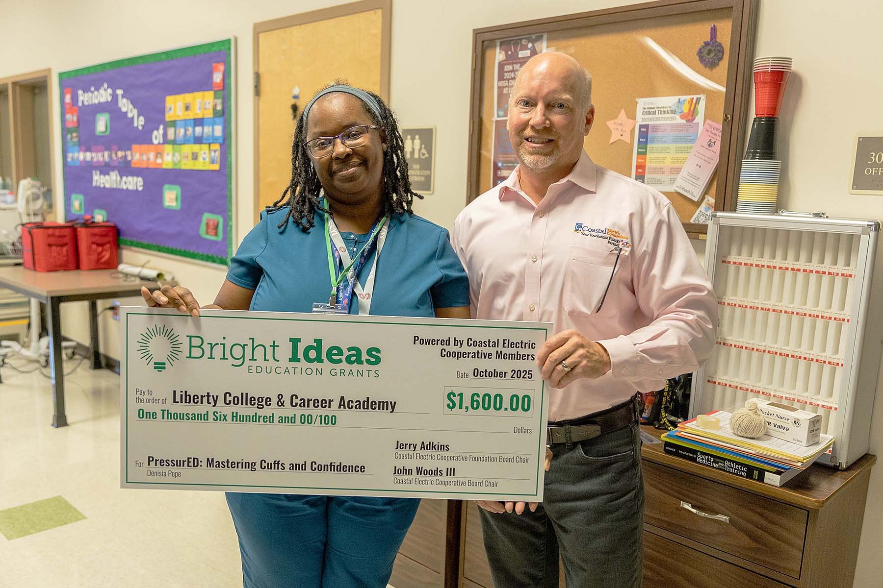 Fettes presents a check to Denisia Pope of Liberty College and Career Academy for $1,600.