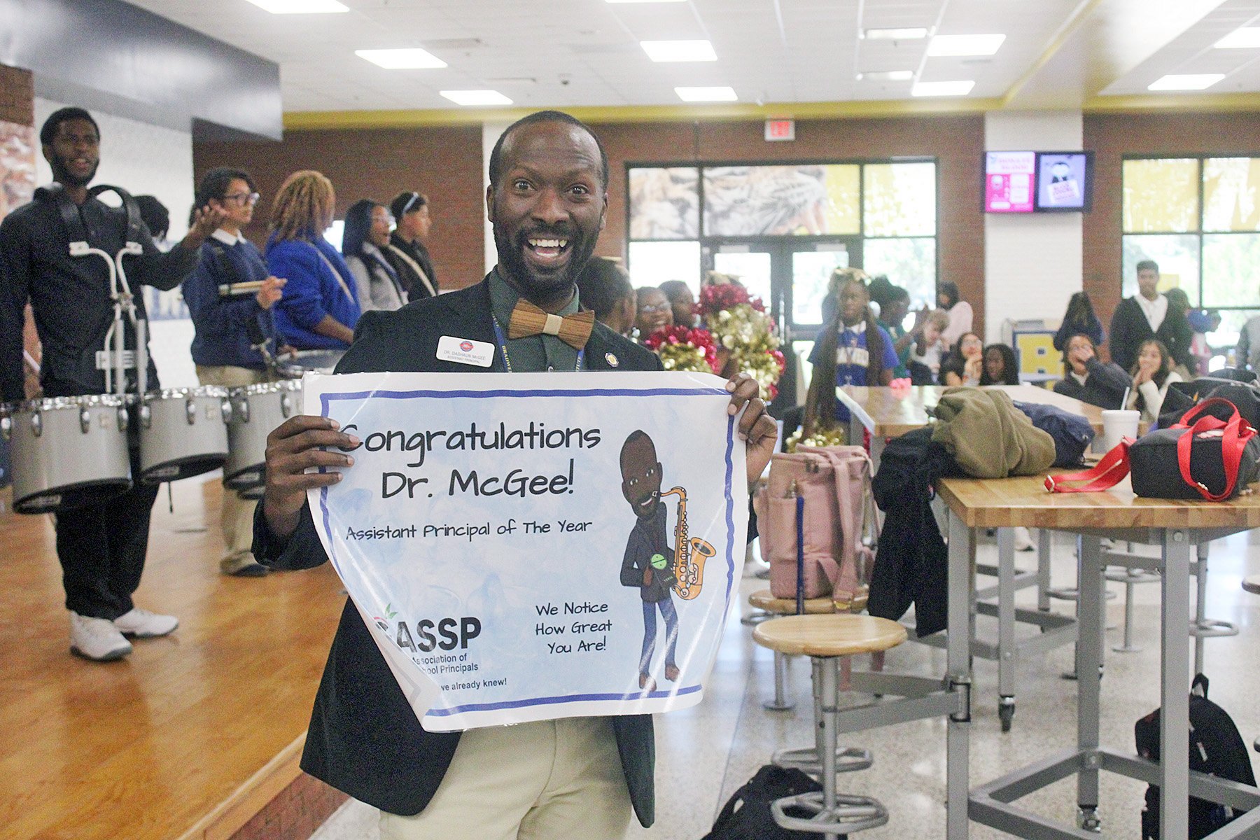 Dr. DeShaun McGee, an assistant principal at Bradwell Institute, holds up the banner for his statewide achievement.  Photo by Pat Donahue