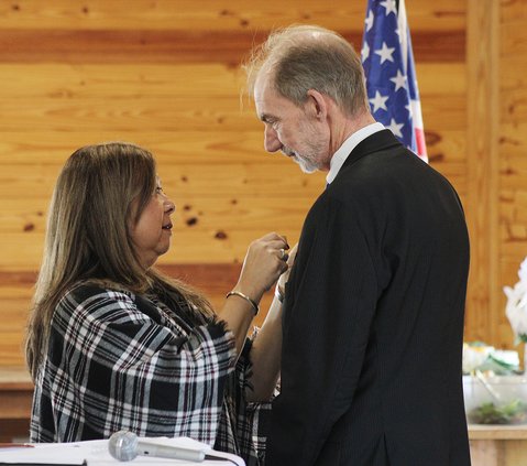 Shanken’s wife Brigitte places his pin on his lapel.